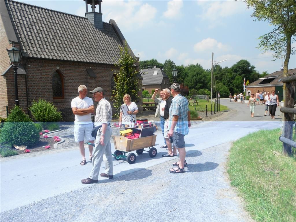 Eine Gruppe von 6 Menschen ziehen einen Bollerwagen hinter sich her
